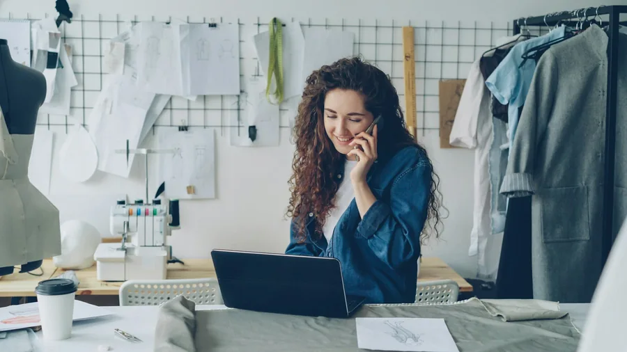 A small studio owner working at a desk with samples behind