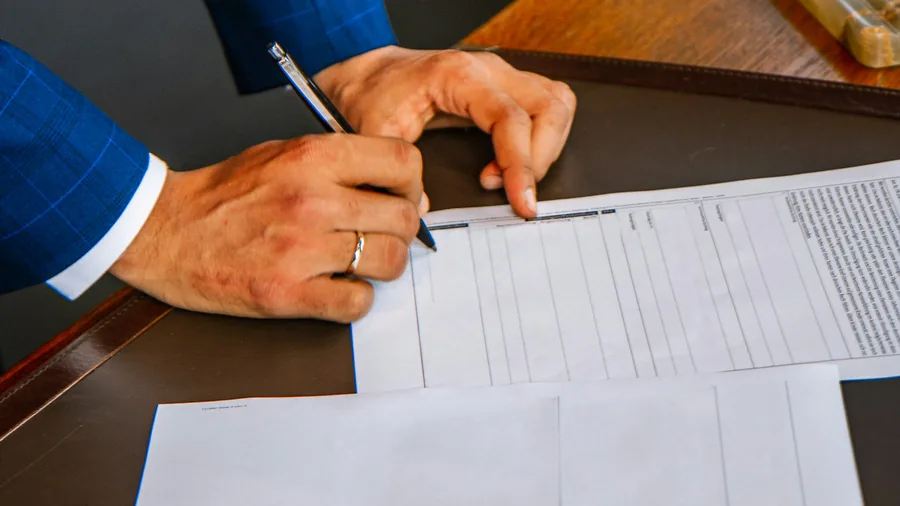 Hands completing customs paperwork at a desk
